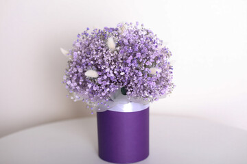 Bouquet of beautiful violet flowers in box on white background
