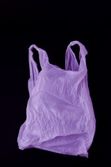 Blank purple plastic bag with handles on dark background
