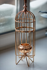 Gold metal candle holder in the shape of a bird cage. Interior detail - 743937423