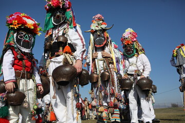 Fototapeta na wymiar People called Kukeri parade in masks and ritual costumes, perform ritual dances to drive away evil spirits in the town of Elin Pelin, Bulgaria.