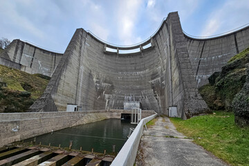 An impressive dam on a river in France showing the water supply channel and the dam wall during the...