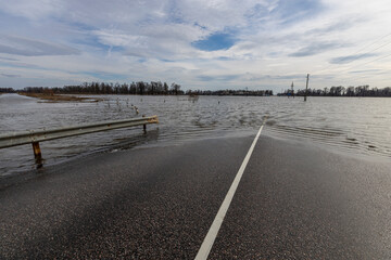 flooded road, early spring flood, river overflowing its banks, environmental pollution, ecology
