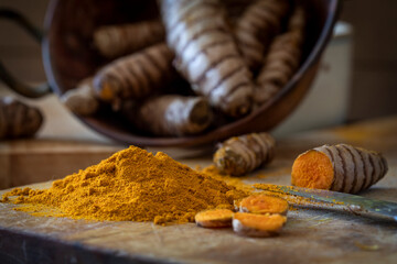 Turmeric root powder close up in a kitchen with blurred background