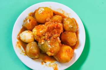 Siomay, traditional Indonesian food, steamed fish dumplings with peanut sauce. The background is green