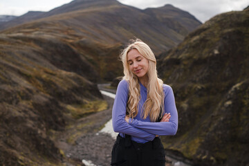 Naklejka premium Traveling and exploring Iceland landscapes and travel destinations. Young traveler enjoying the view of beautiful nature. Female tourist watching spectacular scenery. Summer tourism by Atlantic ocean