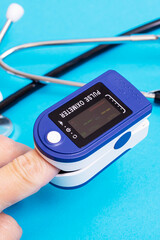 Stethoscope and pulse oximeter on blue background