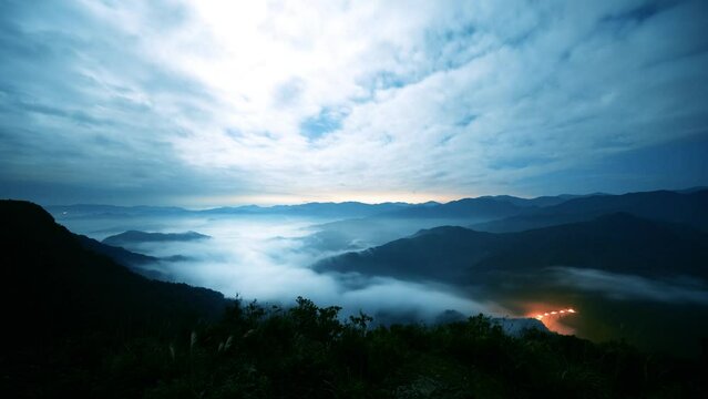 The sea of clouds on a quiet moonlit night makes you feel unpredictable. View of the mountains surrounding Emerald Reservoir. Xindian District, Taiwan.