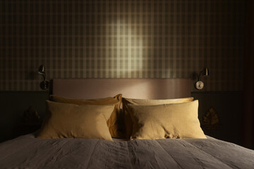 Morning light shining in on a interior of a bedroom with tweed pattern wallpaper.