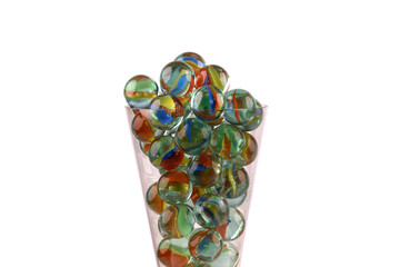 Close-up of a champagne glass filled with glass marbles isolated