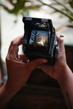 Closeup image of photographer checking photos he made on analog camera