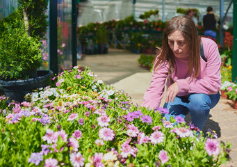 Woman buying flowers to decorate her garden in a plant nursery