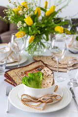 A Passover table setting with a bouquet of tulips	