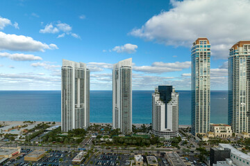 Aerial view of Sunny Isles Beach city with congested street traffic and luxurious highrise hotels and condos on Atlantic ocean shore. American tourism infrastructure in southern Florida