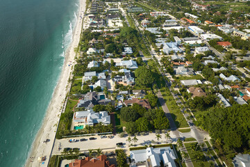 Aerial view of wealthy waterfront neighborhood. Expensive mansions between green palm trees on Gulf...