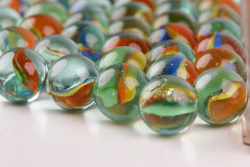 Close-up of a group of colorful glass marbles with natural shadows