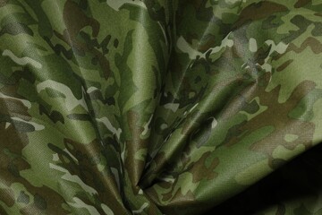 Texture of crumpled camouflage fabric as background, top view