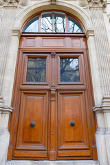 Old ornate door in Paris - typical old apartment buildiing. - 744013444