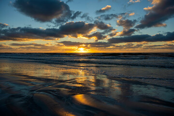 Ocean sunset landscape with soft evening sea water waves crushing on sandy beach