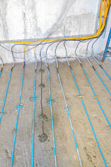 Warm floor cable installation on concrete at a construction site