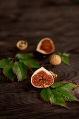 sliced juicy figs on a dark wooden background.