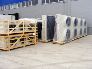 Two industrial air coolers neatly stacked on a wooden pallet at a construction site