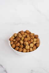 Hazelnut in a white bowl on a marble table