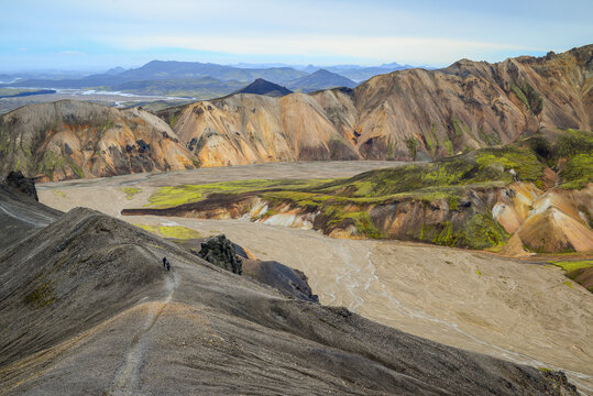 Two hikers on the ridge trail approaching the summit of Bl&aacute;hnj&uacute;kur volcano, Landmannalaugar, Fjallabak Nature Reserve, Iceland.