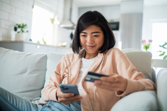 Young woman online shopping at home with credit card