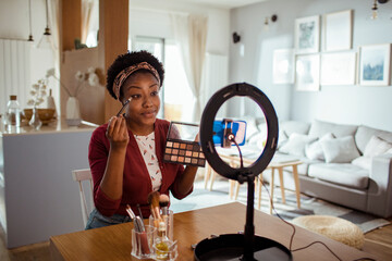 African American Woman Recording Makeup Tutorial with Ring Light at Home
