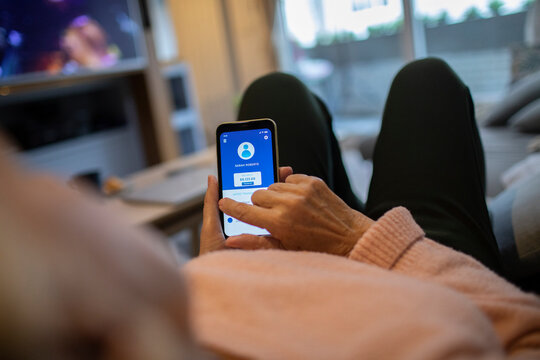 Senior woman checking bank balance on smartphone app at home