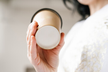 Close up mockup of the bottom of a paper cup in the hands of a woman