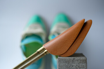 Metal Shoe Shape Holder on a Blurred Background of the Aqua and Lime Color Sneakers. Shallow depth...