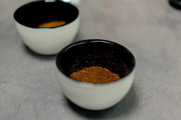 close-up at coffee factory there are white bowls with freshly ground coffee