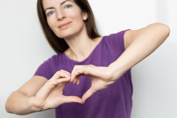 Inspire inclusion. Woman holding her hands in the shape of a heart and holding them in front of...