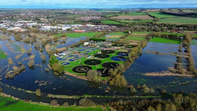 Aerial shot of sewerage farm on the River Avon when river is flooded and overflowing, Salisbury in the distance.