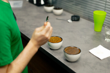 close-up at coffee roasting factory in the kitchen, a bowl of coffee is collected with spoons of...