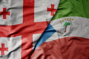 big waving national colorful flag of equatorial guinea and national flag of georgia .