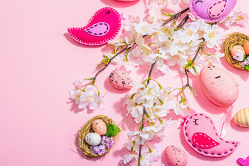 Gentle Easter composition with cherry flowers and handmade felt birds. Decorative eggs and nest