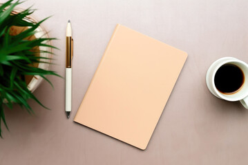 Top view notebook with empty page, a pen, plant and cup of tea. Copy space. Flat lay