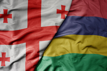 big waving national colorful flag of mauritius and national flag of georgia .