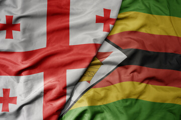 big waving national colorful flag of zimbabwe and national flag of georgia .