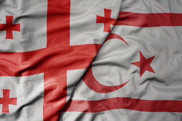 Fototapeta premium big waving national colorful flag of northern cyprus and national flag of georgia .