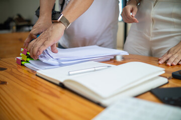 secretary is searching through pile of important documents on office table deliver them to manager...