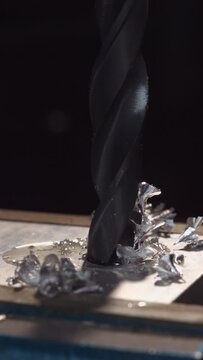 Experience the artistry of metalwork with this vertical 4K slow-motion clip of a drill in action.