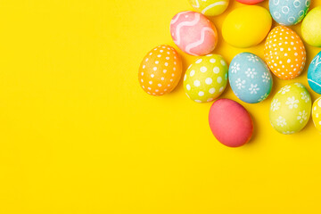 Easter eggs on a bright yellow background. Easter celebration concept. Colorful easter handmade decorated Easter eggs. Place for text. Copy space.