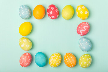 Easter eggs on a bright turquoise background. Easter celebration concept. Colorful easter handmade decorated Easter eggs. Place for text. Copy space.