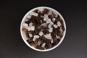 top view of a bowl of crystal sugar on black background