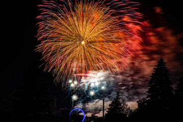 Montreal, Canada - June 25 2022: Fire works show with quarter moon in background at La Ronde in...