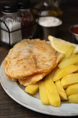 Delicious fish and chips on wooden table, closeup