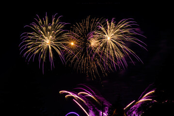 Montreal, Canada - June 25 2022: Fire works show with quarter moon in background at La Ronde in Montreal